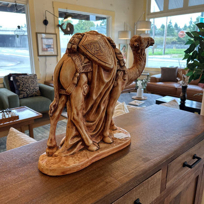 Wooden camel sculpture on a wooden surface in a living room