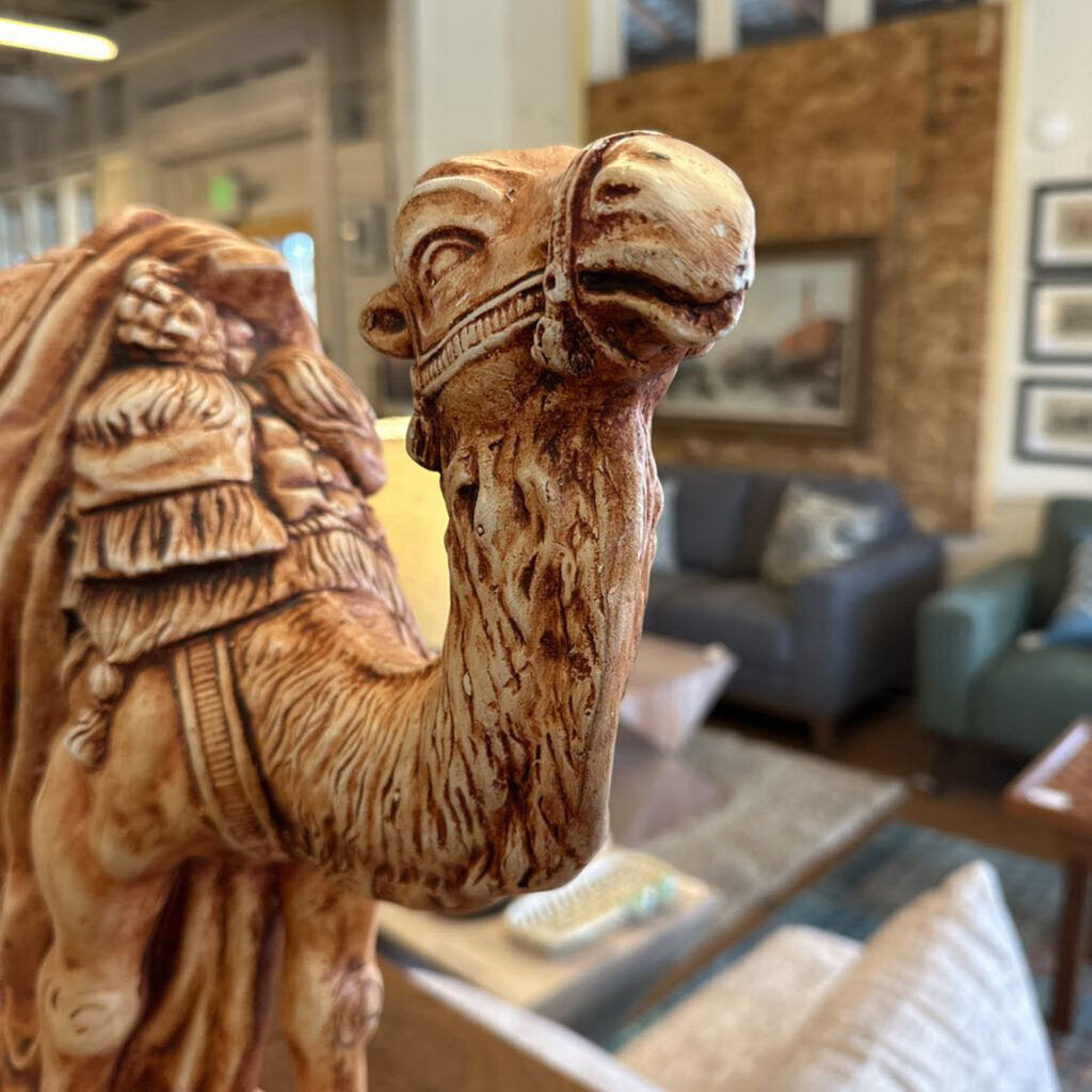 Carved wooden camel figure in a living room setting