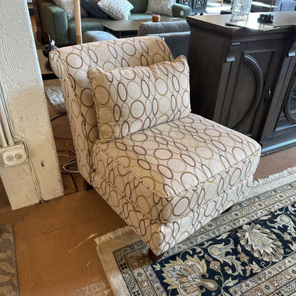 Patterned armchair in a room with a rug and furniture.