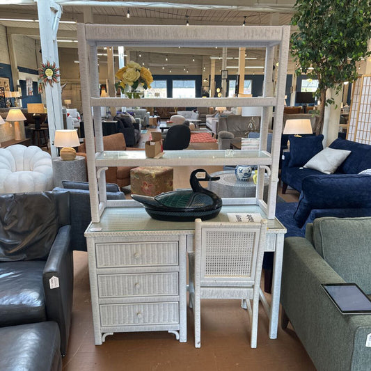 White rattan side table with mirror in a furniture store setting