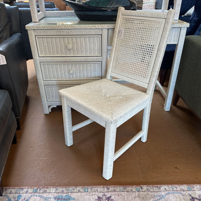 Wicker chair in a room with furniture and a rug.