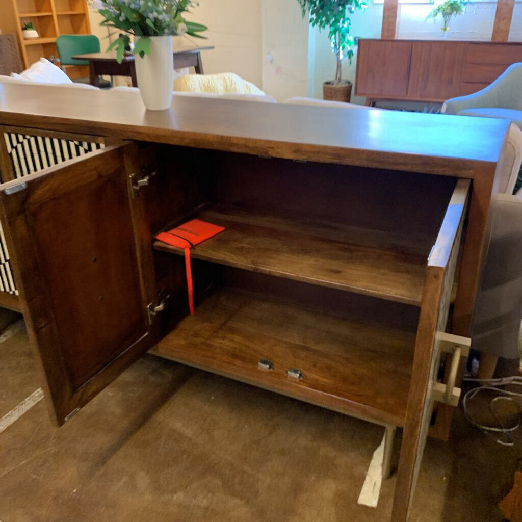 Wooden cabinet with open door in a room with furniture and decor.
