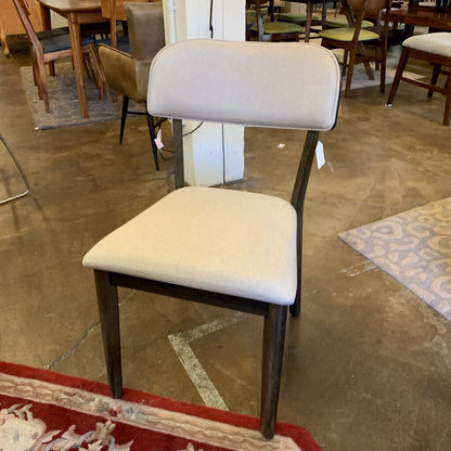 Chair with beige cushioned seat and backrest in a store setting