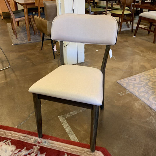 Chair with beige cushioned seat and backrest in a store setting