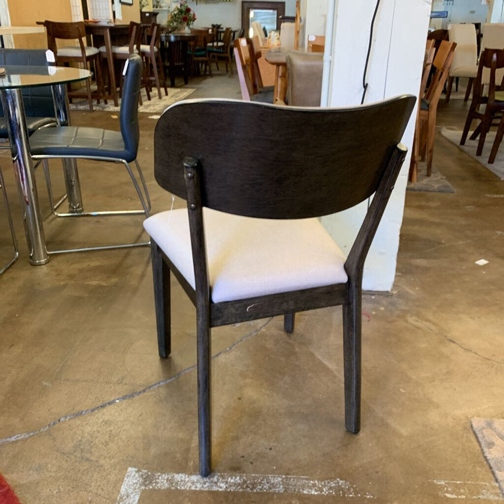 Chair with a white cushion on a brown floor in an indoor setting