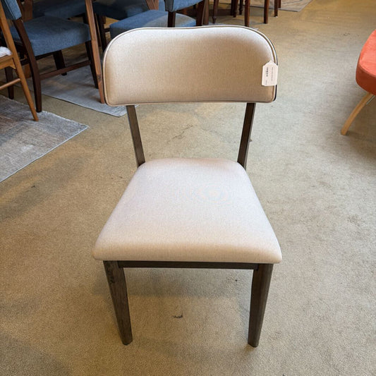 Beige chair with wooden legs on a carpeted floor