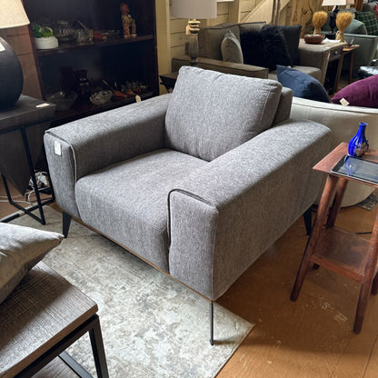 Gray sofa in a living room setting with furniture and decor.