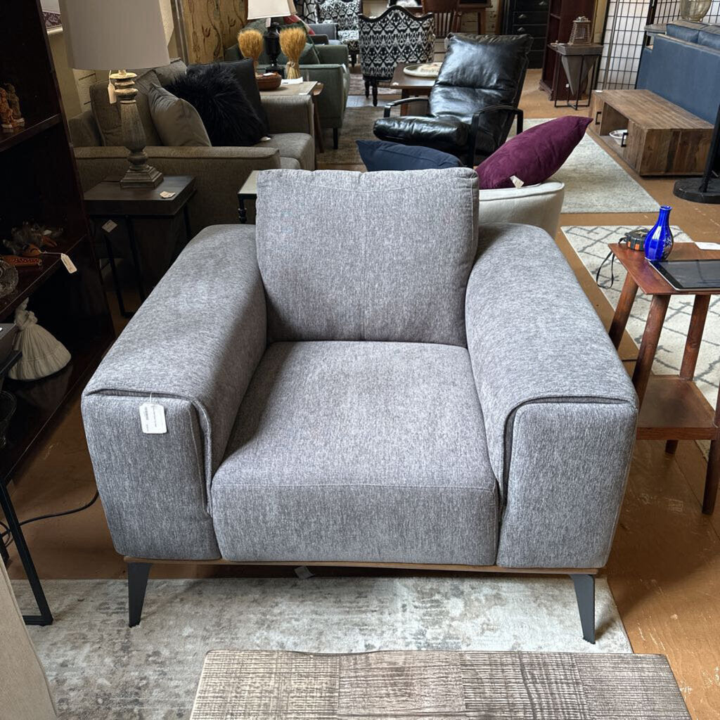 Gray armchair in a room with other furniture and decor