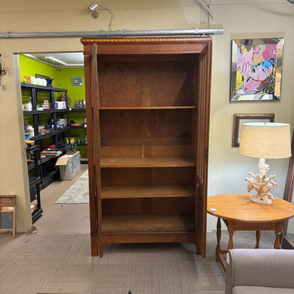 Wooden bookshelf in a room with furniture and decor