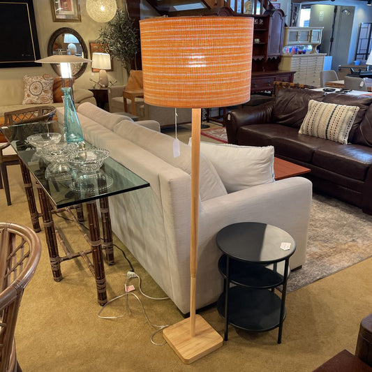 Living room with a white sofa, brown leather couch, glass coffee table, and a tall floor lamp.