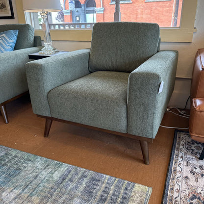 Green armchair in a room with a lamp and window