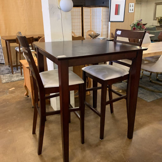 Wooden dining table with four bar stools in a showroom setting