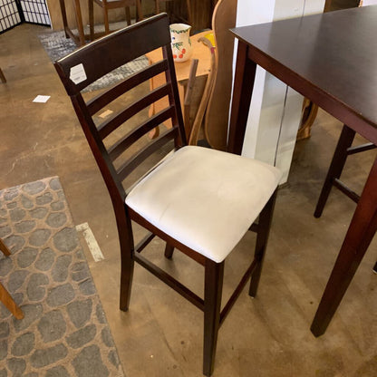 Wooden chair with a white cushion on a tiled floor.