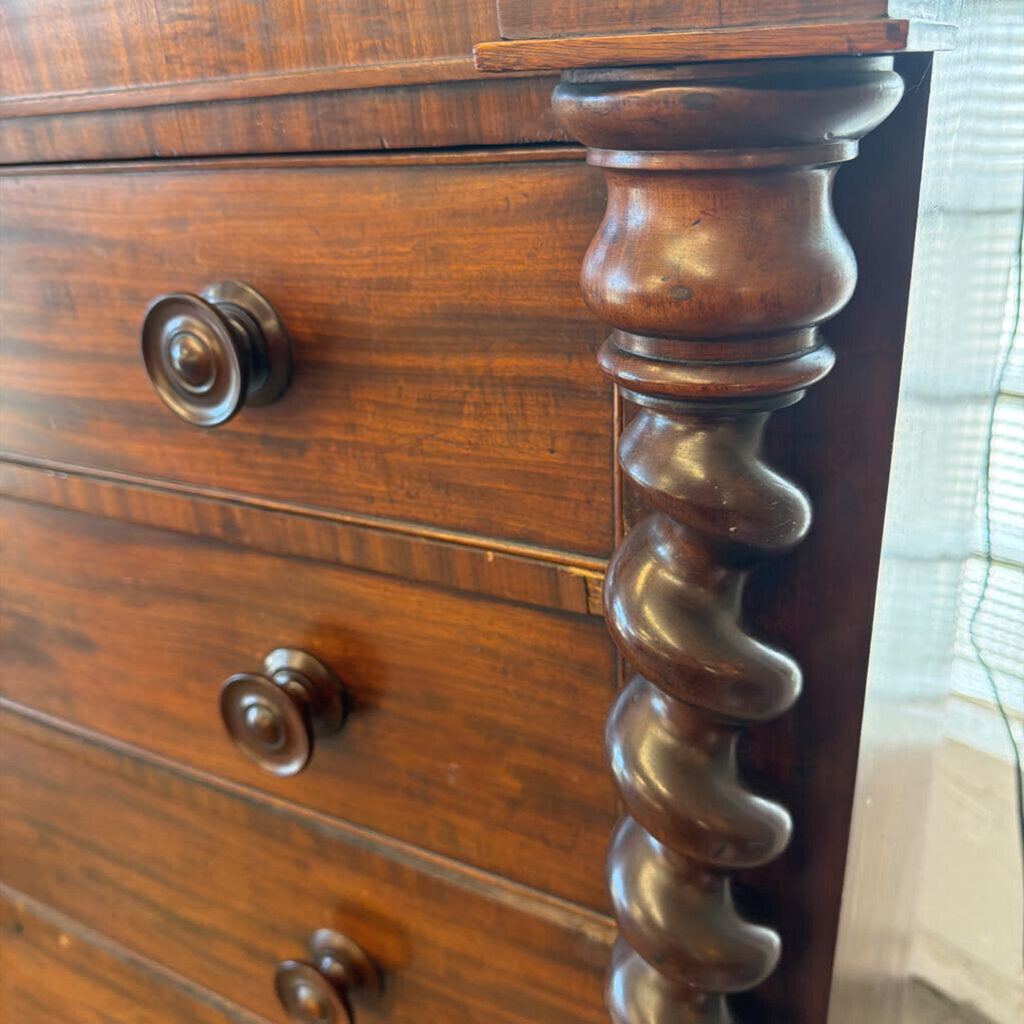 Close-up of a wooden dresser with decorative turned legs