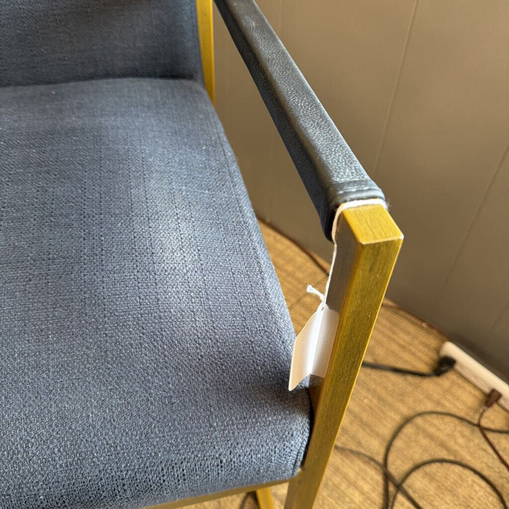 Gray chair with wooden armrests on a wooden floor.