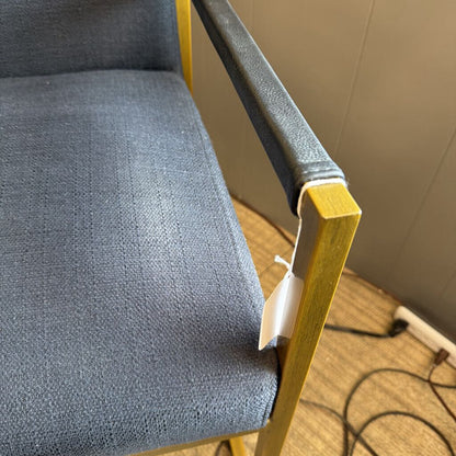 Gray chair with wooden armrests on a wooden floor.