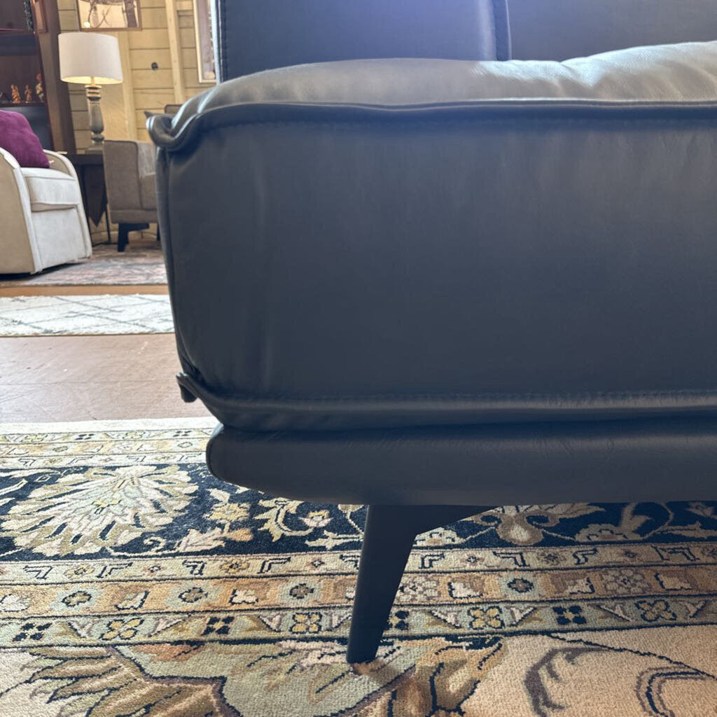 Gray sofa on a patterned rug in a living room setting