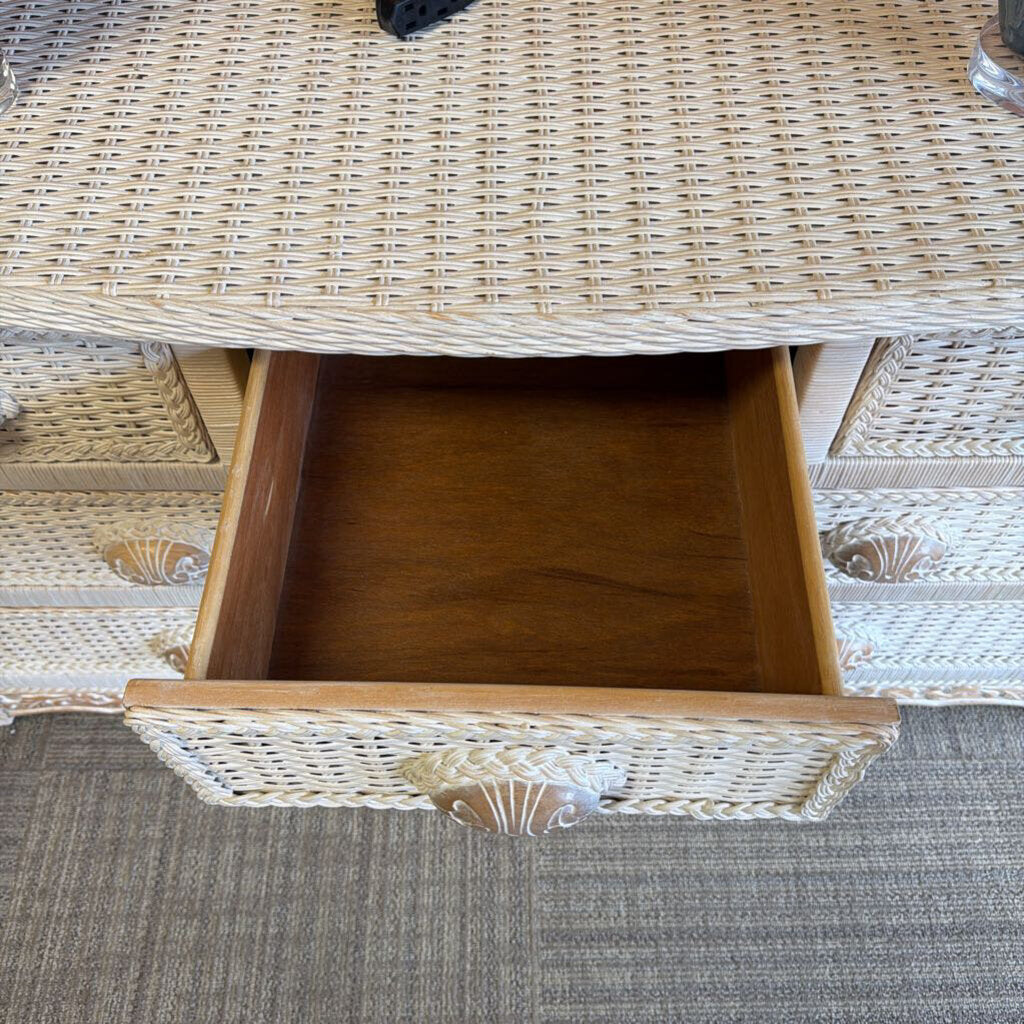 Wicker side table with a drawer open, showing a shell design.