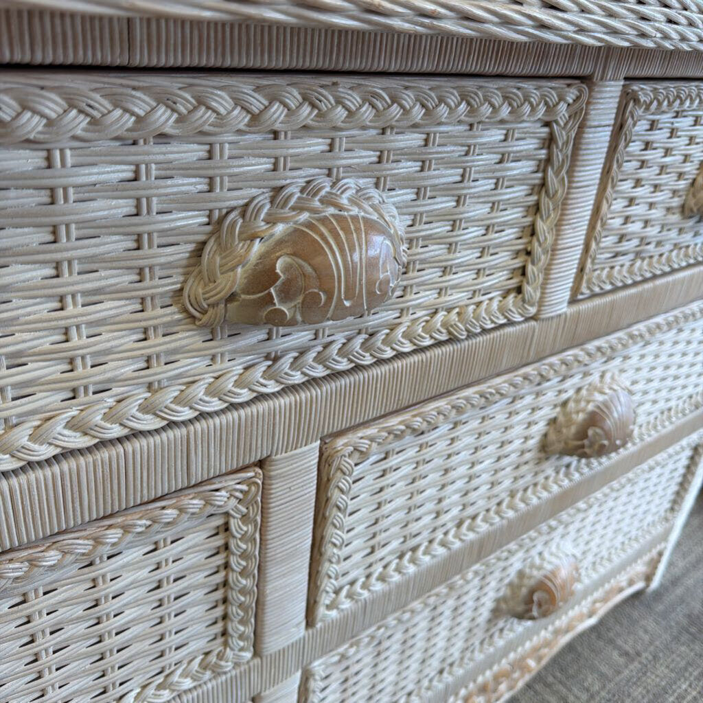 Wicker chest with shell-shaped handles on a neutral background