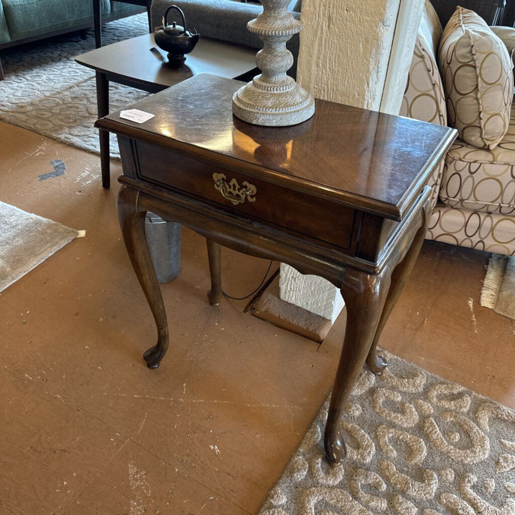 Wooden side table with a decorative lamp in a living room setting