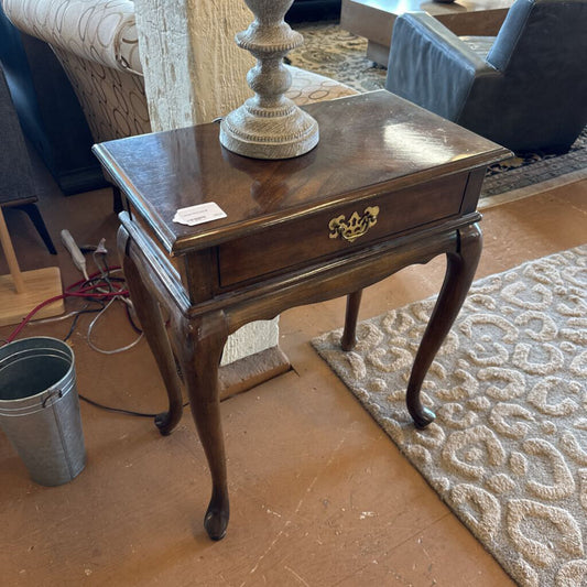 Wooden side table with a lamp on a patterned rug