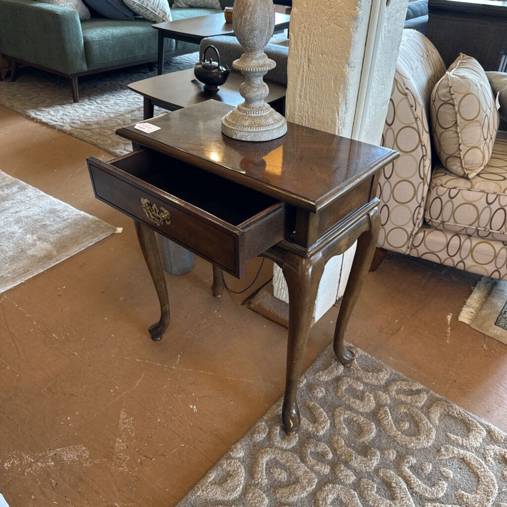 Wooden side table with a drawer in a living room setting