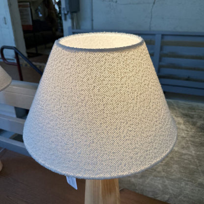 Textured lampshade on a wooden stand with a blurred background