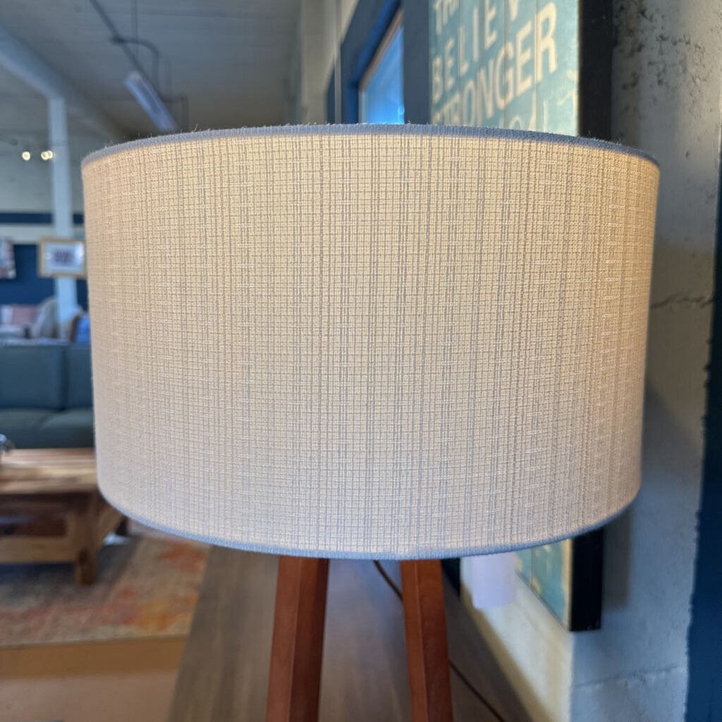 Textured lampshade on a wooden stand in an indoor setting