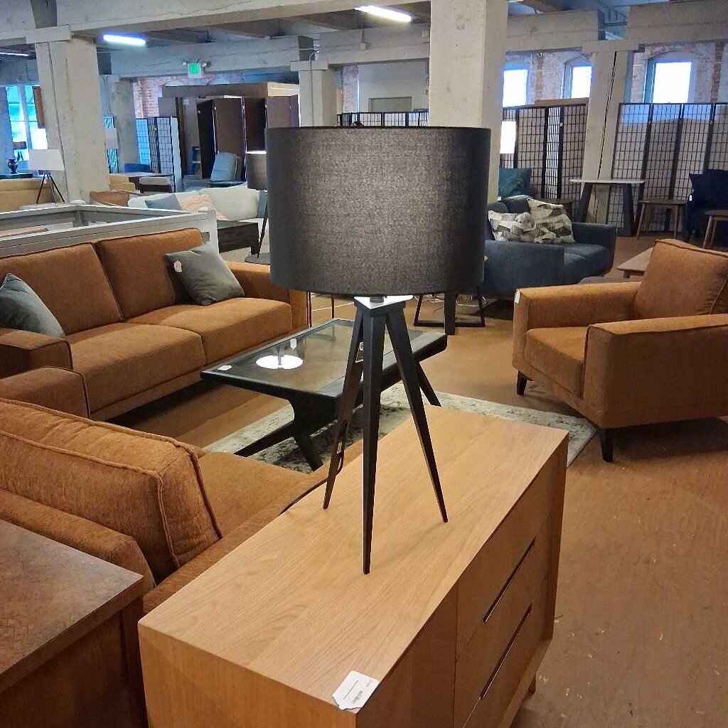 Living room setup with brown sofas, wooden coffee table, and lamp in a showroom.