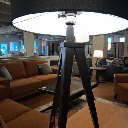Lamp with a tripod base in a room with furniture and decor