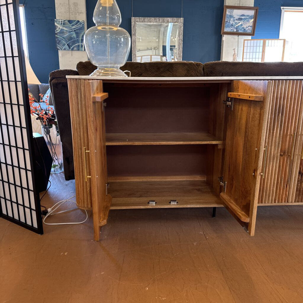 Wooden cabinet with open doors in a room with blue walls and decorative items.