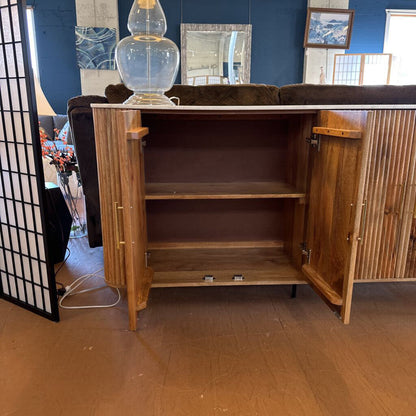 Wooden cabinet with open doors in a room with blue walls and decorative items.