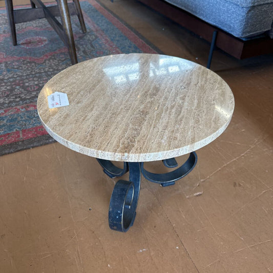 Round marble table with metal legs on a wooden floor