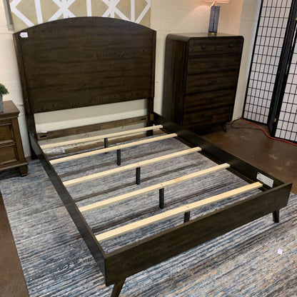 Wooden bed frame with slats on a rug in a room setting