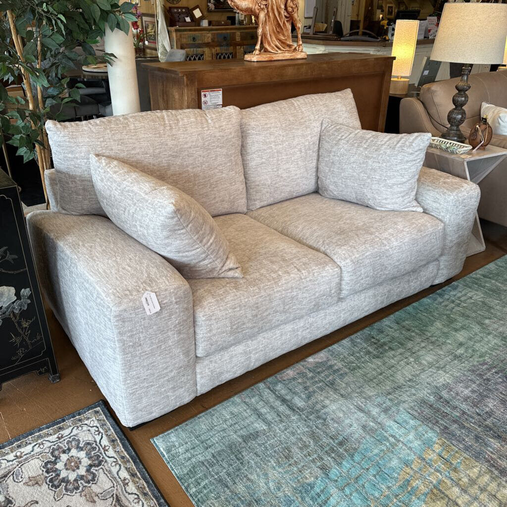 Gray sofa in a room with decorative elements and furniture.