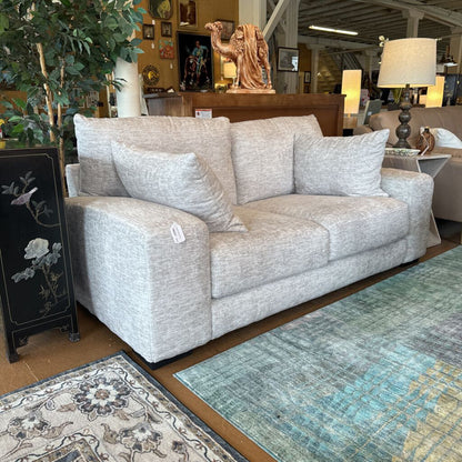 Gray sofa with decorative pillows in a furniture store setting