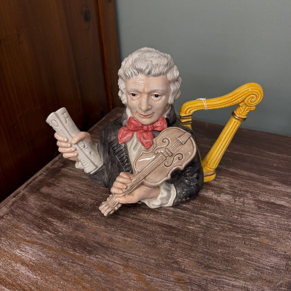 Statue of a man playing a violin on a wooden surface