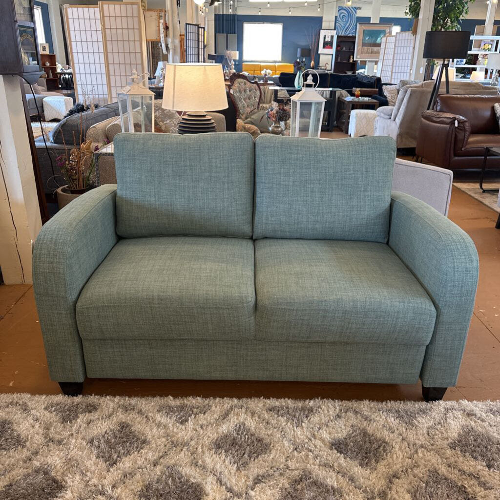 Blue sofa in a showroom with other furniture and decor items.