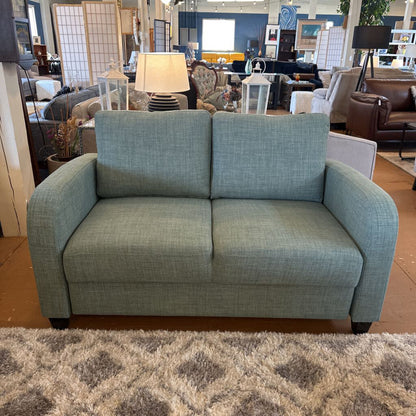 Blue sofa in a showroom with other furniture and decor items.