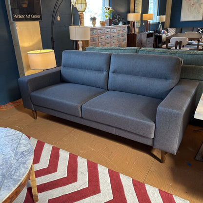 Blue sofa in a room with a red and white patterned rug