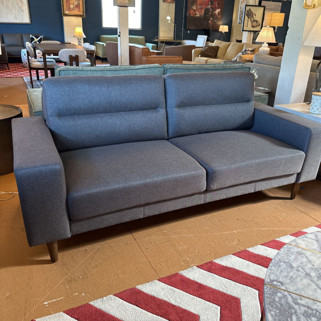 Blue sofa in a showroom with other furniture and decor.