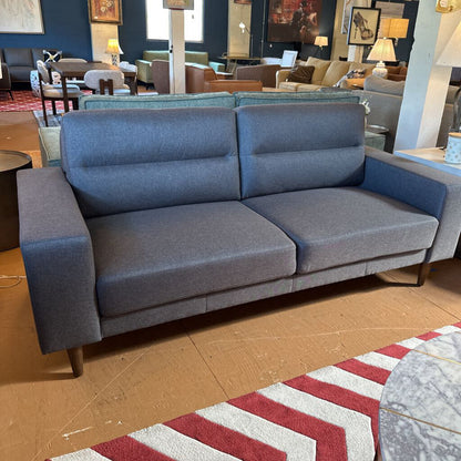 Blue sofa in a showroom with other furniture and decor.