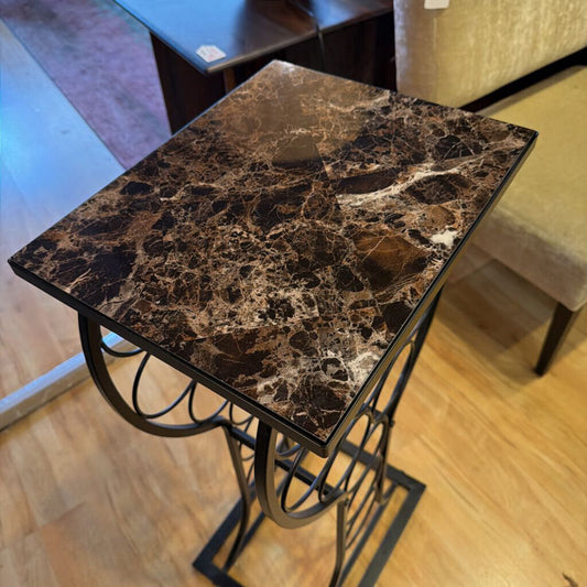 Small side table with marble-like top and metal base in a room setting