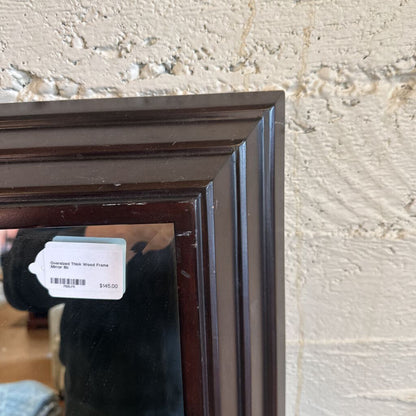 Dark wood picture frame with a price tag on a textured wall.