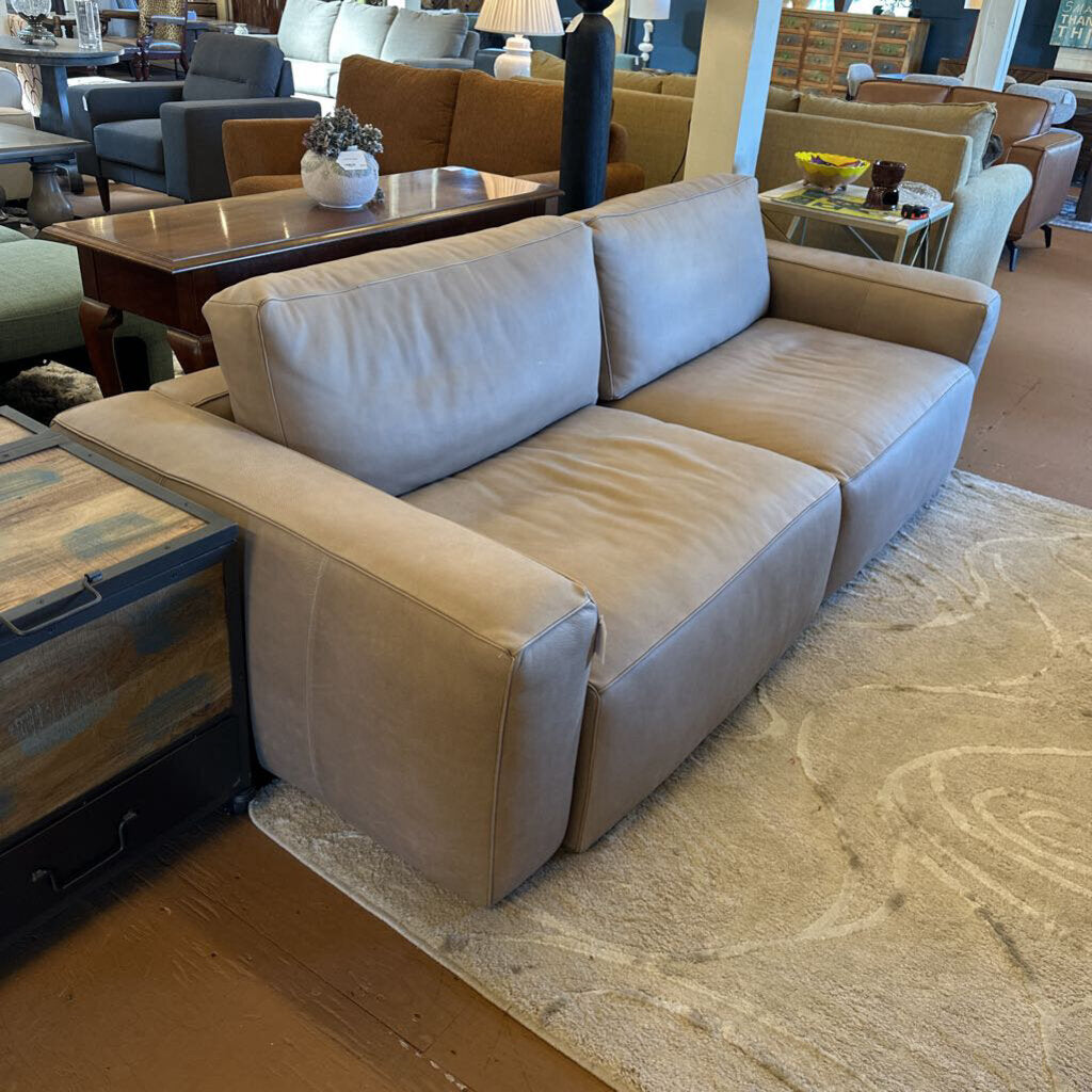 Beige sectional sofa in a showroom setting with other furniture.