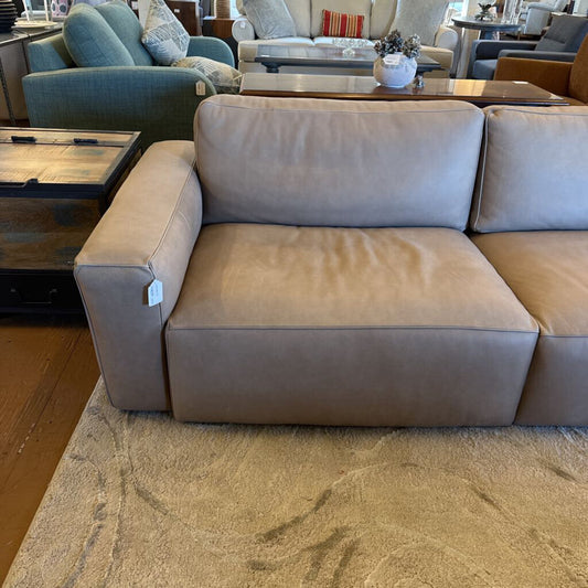 Beige sectional sofa in a living room setting with other furniture.