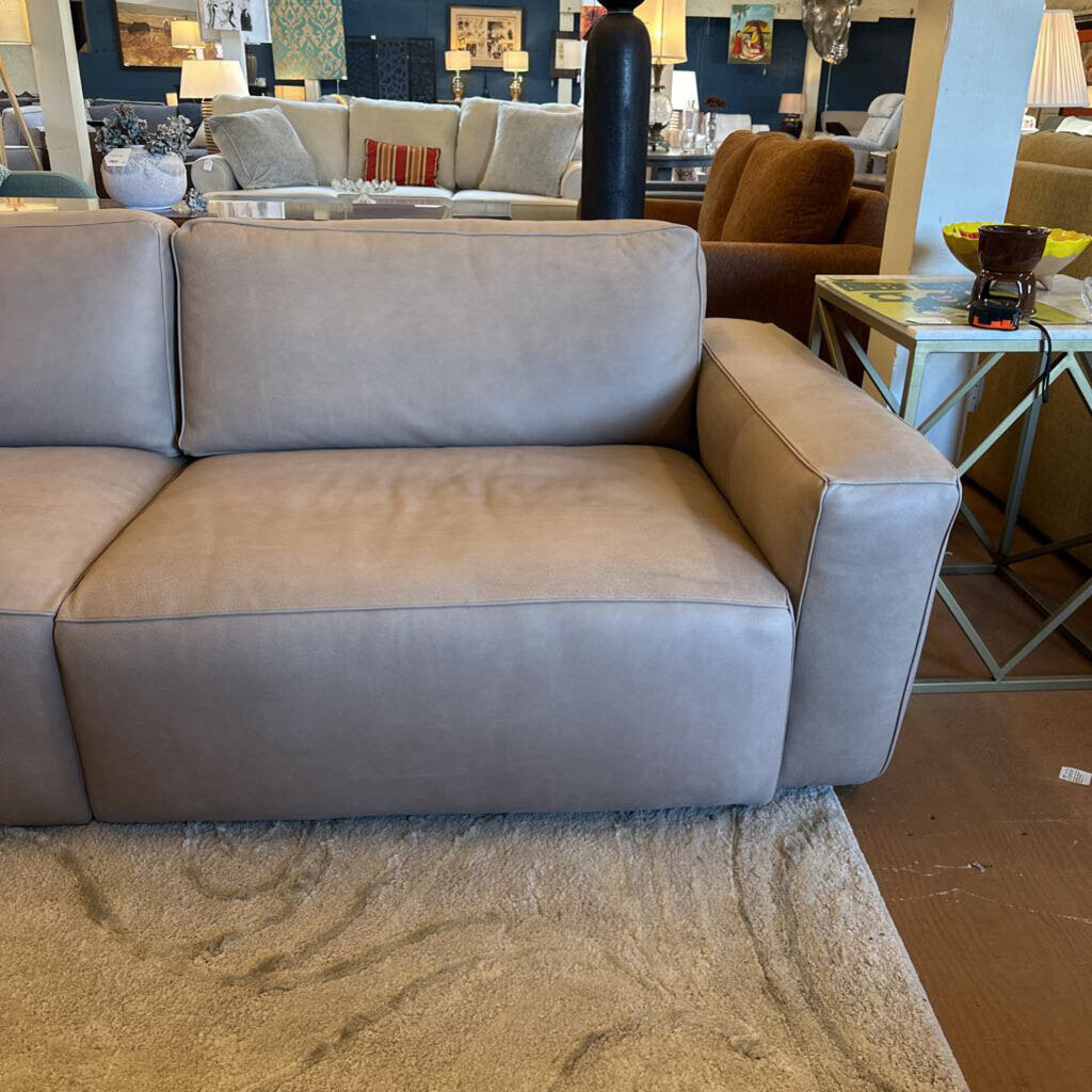 Beige sectional sofa in a room with other furniture and decor.