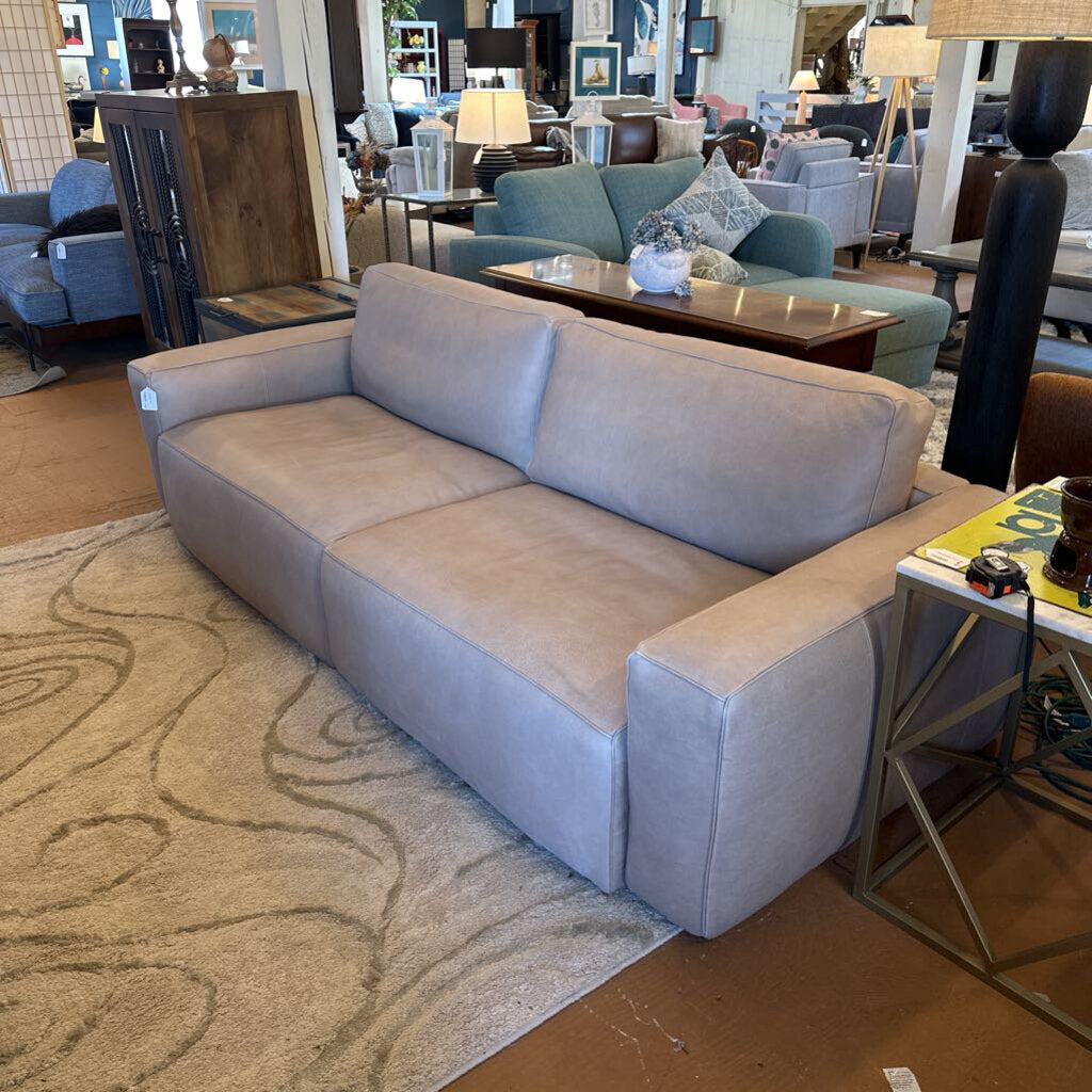 Gray sofa in a room with furniture and decor