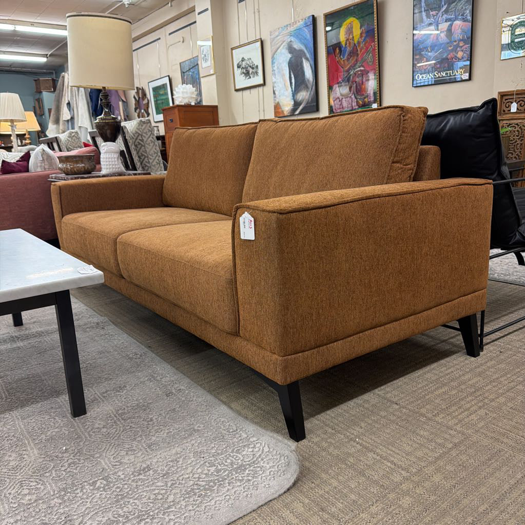 Brown sofa with a price tag in a furniture store setting