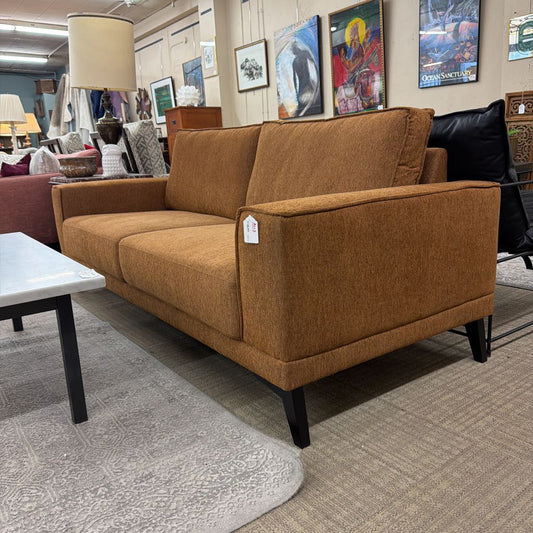 Brown sofa with a price tag in a furniture store setting